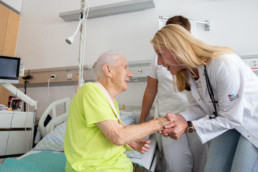 Eine Ärztin begrüsst eine ältere Patientin