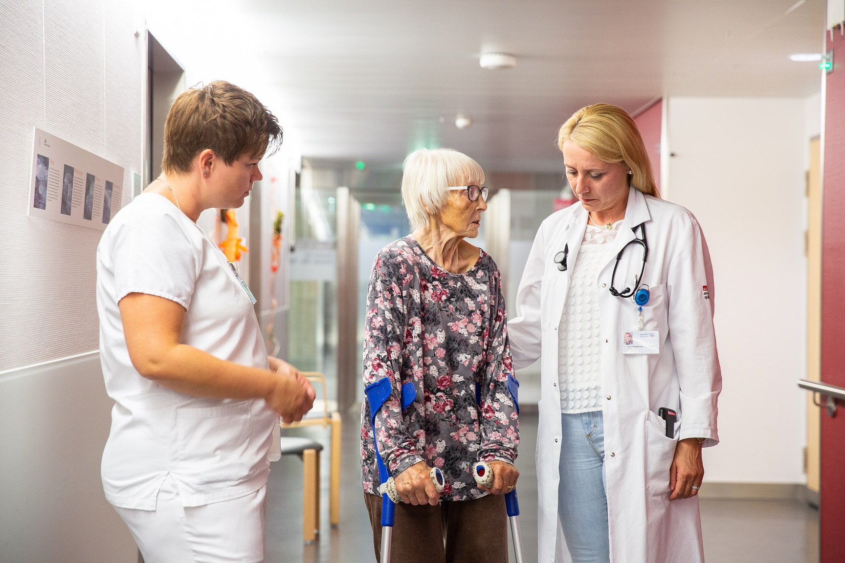 Eine ältere Patientin im Gespräch mit ihrer Ärztin und ihrer Pflegerin