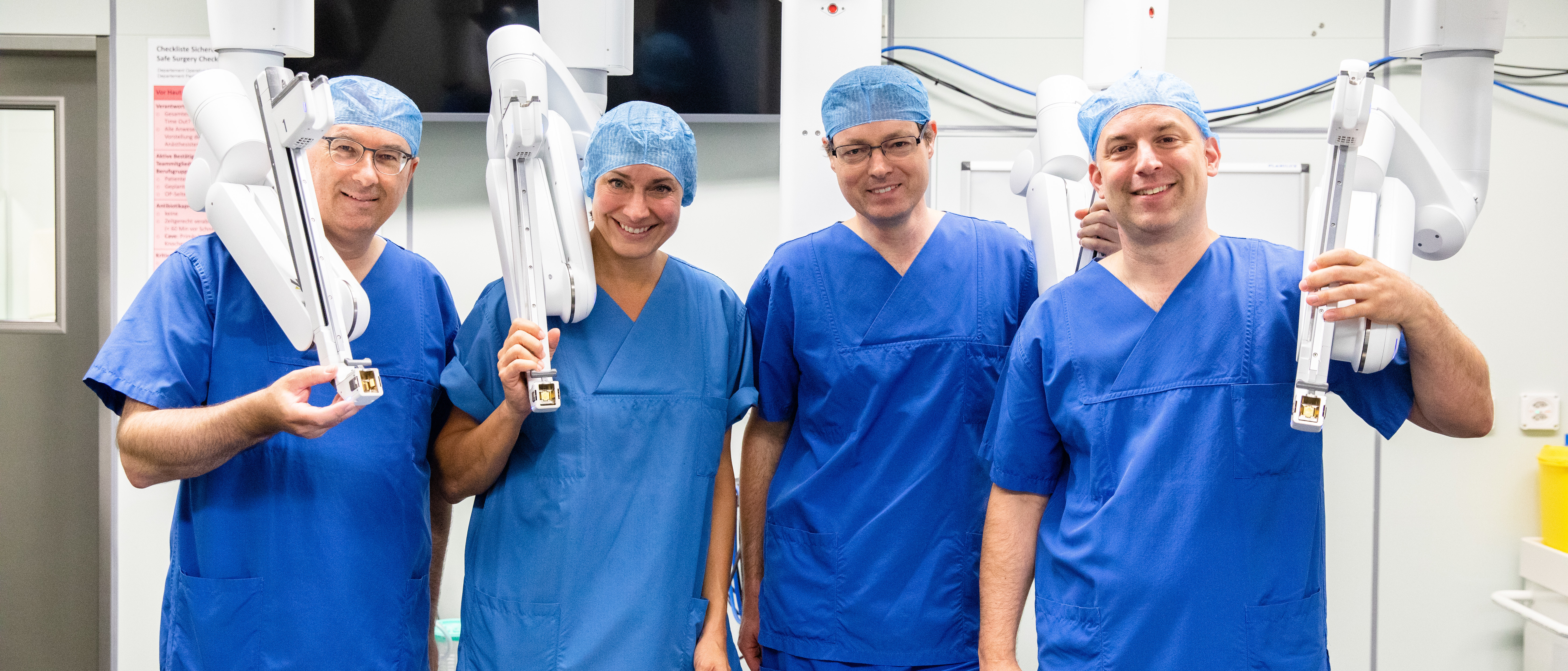 Vier Chirurginnen und Chirurgen vor dem Da Vinci