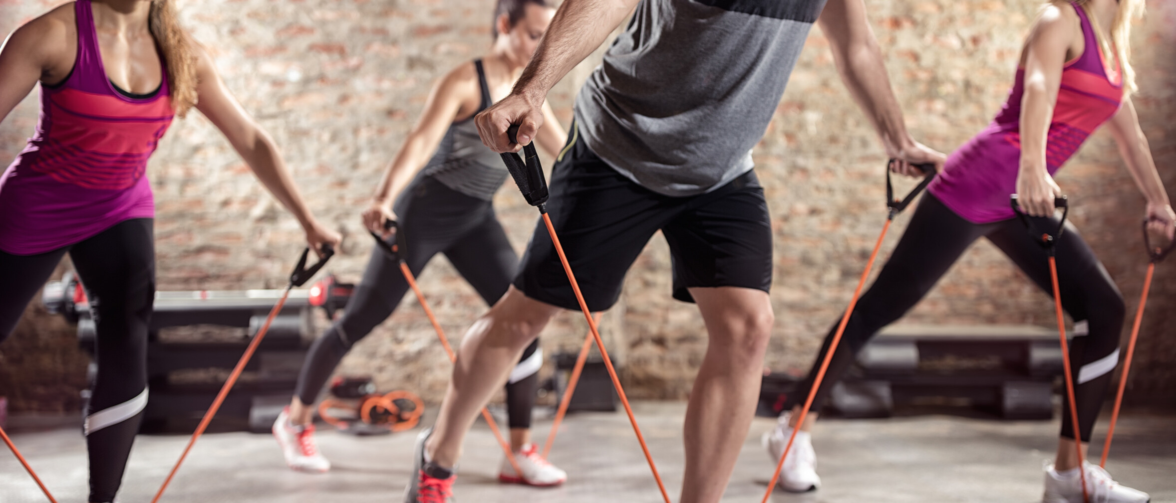 Sportliche Menschen, die mit Stretchingbändern trainieren