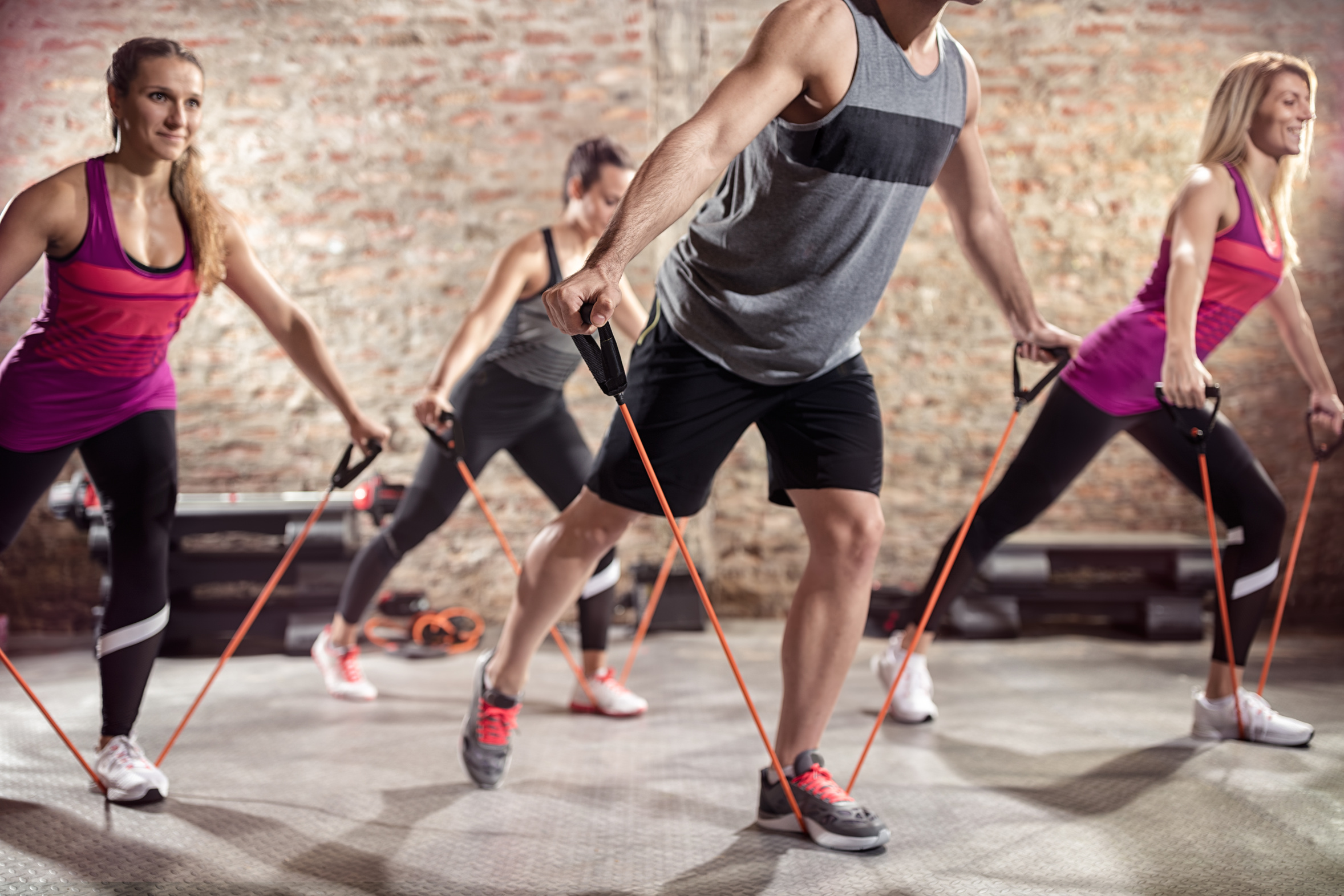 Sportliche Menschen, die mit Stretchingbändern trainieren
