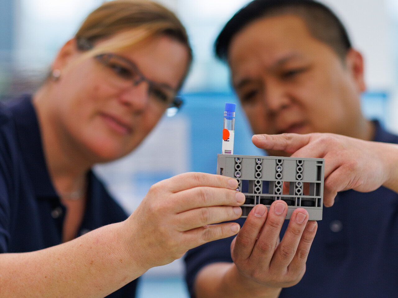 Zwei Mitarbeitende im Labor schauen sich eine getestete Blutproben an.