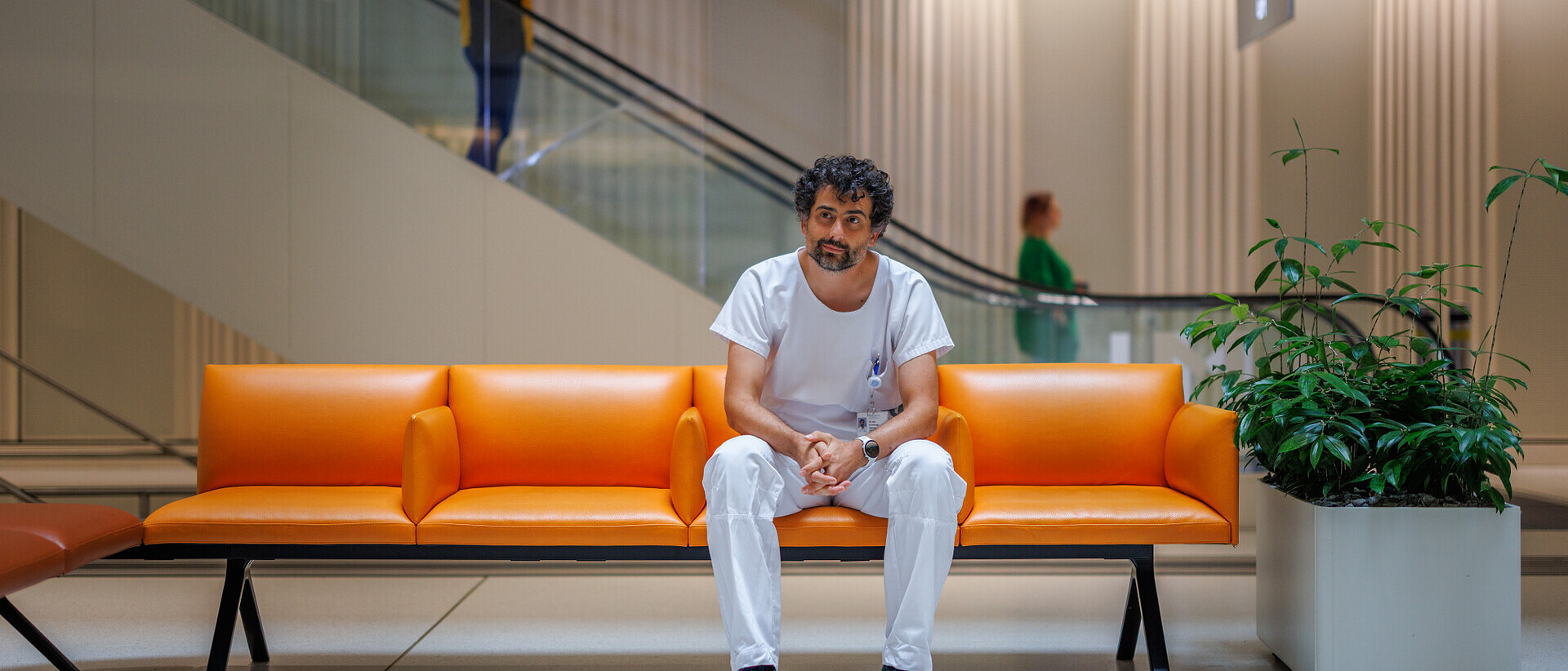 Herzchirurg sitzt auf einer Bank beim Empfang.